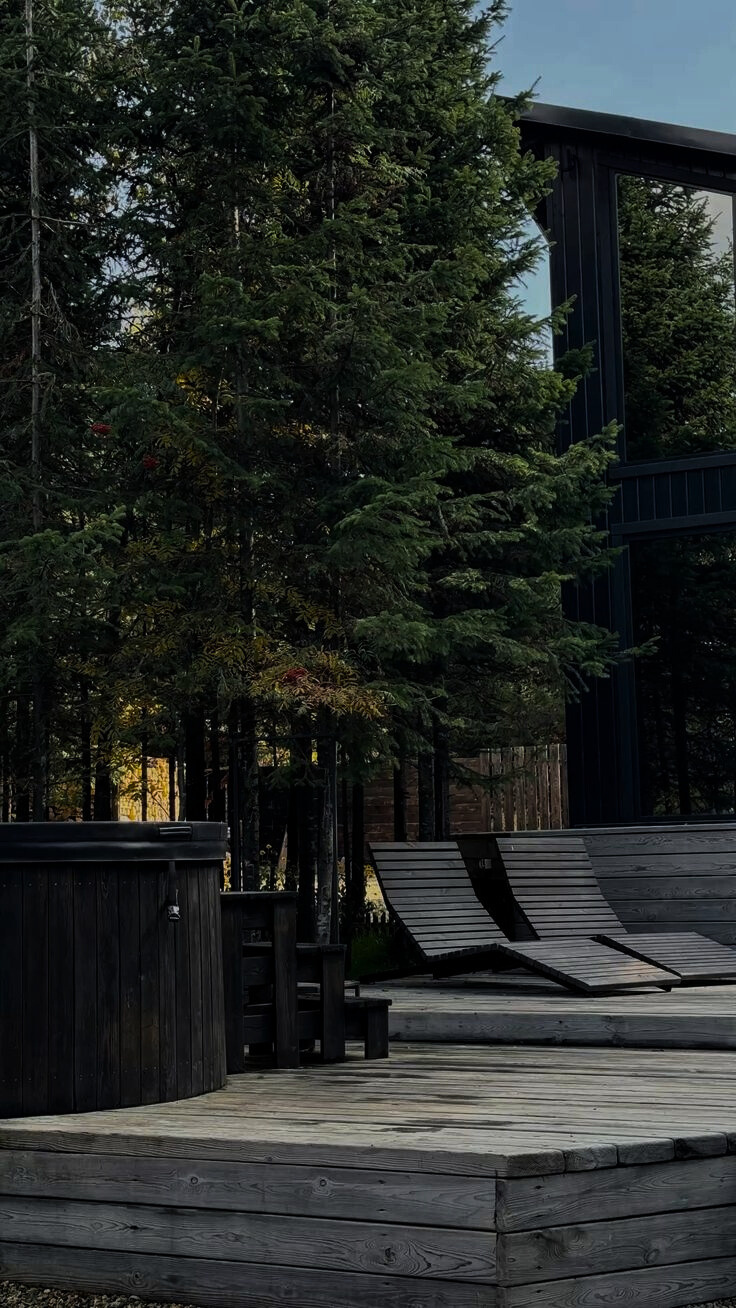 An outdoor bathing area and timber accommodation set among trees